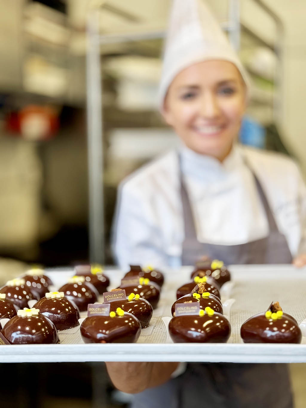 Pasticcere che consegna torte al cioccolato monoporzione a forma di cuore